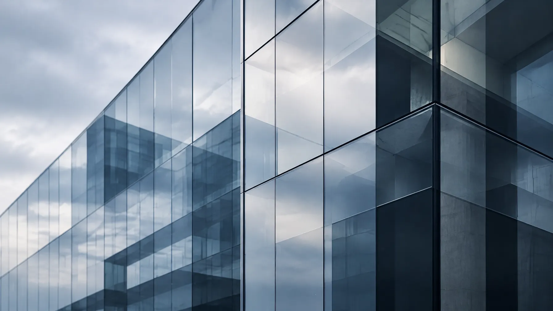 Modern glass office facade with layered slate-blue reflections